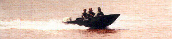 Paymasters traveling by outboard motorboat on the Bassac River